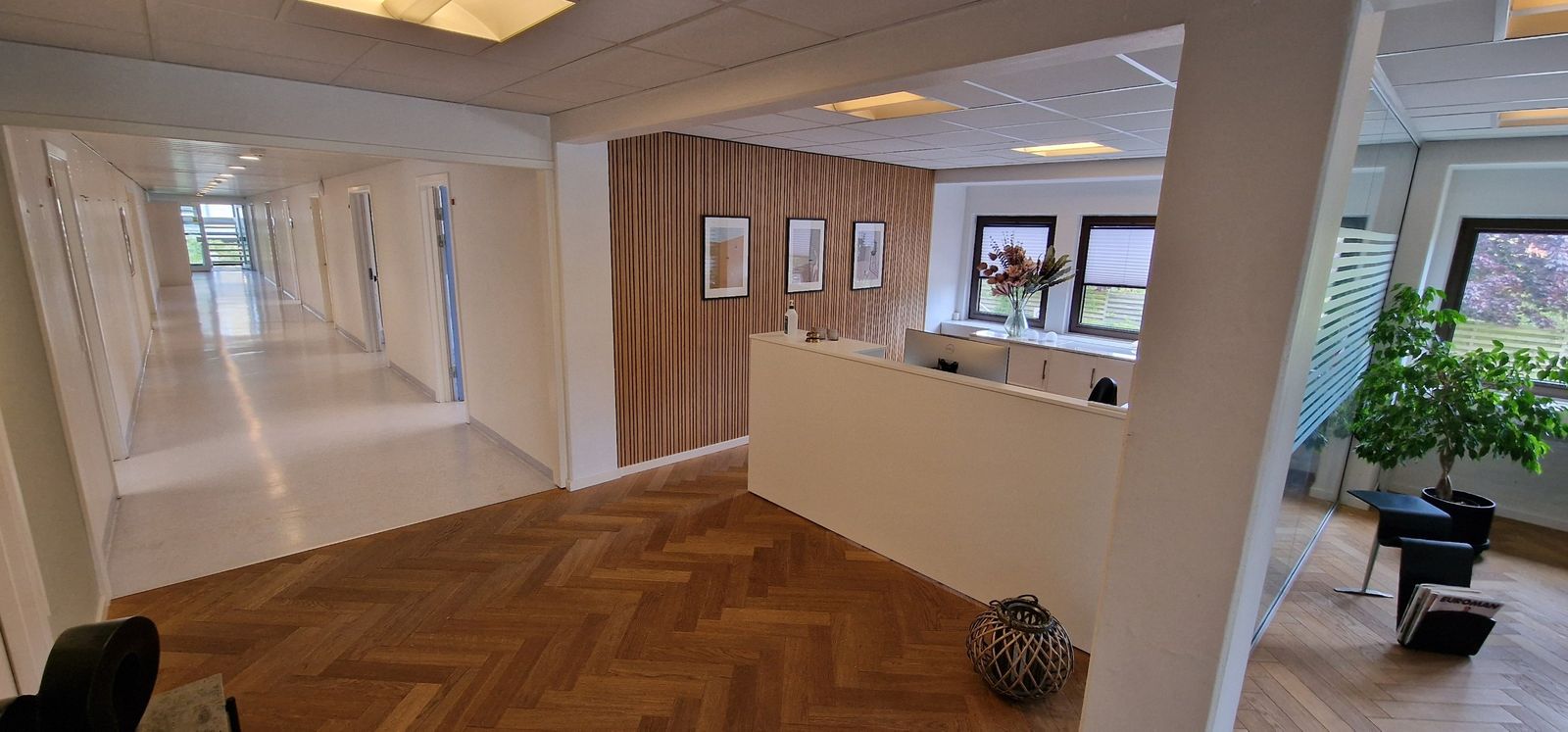 Klinikkens reception med træpanel og indrammede billeder