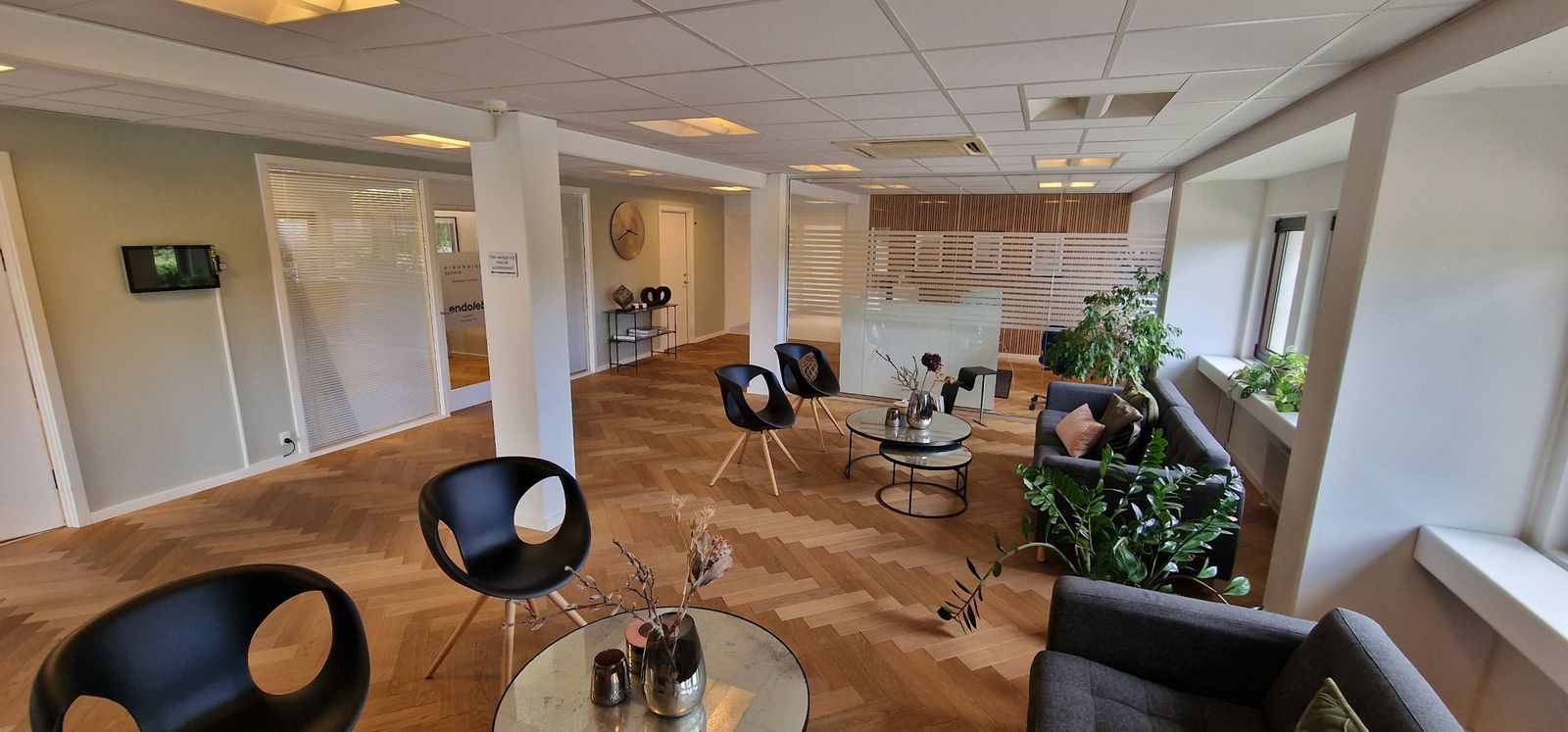 Venteværelset med sorte stole, sofaer og sildebensparket